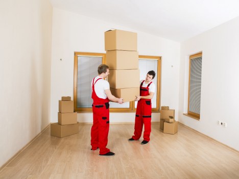 Specialist movers navigating a piano through a narrow Enfield staircase